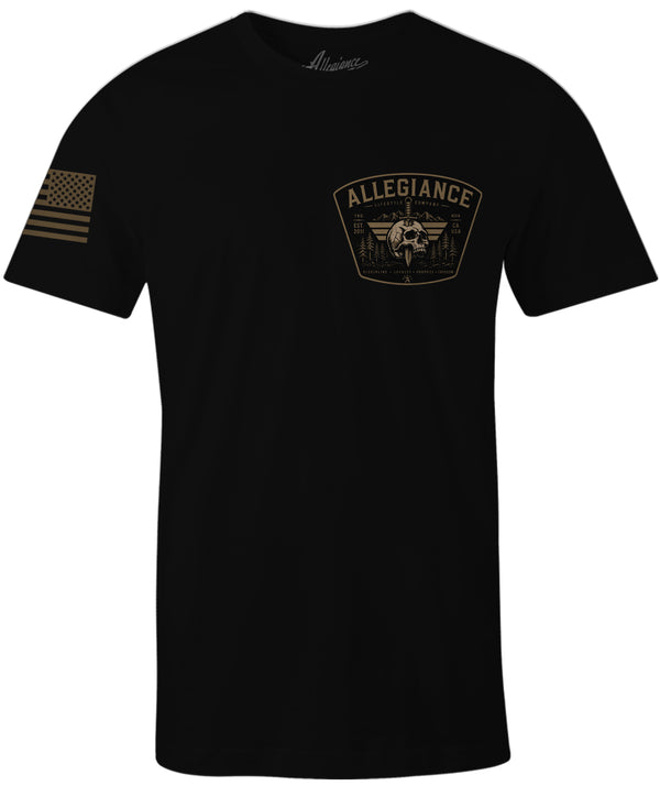 A black short-sleeve t-shirt with a tan/gold 'ALLEGIANCE' winged emblem printed on the left chest and a tan/gold American flag graphic on the right sleeve, shown against a plain white background.